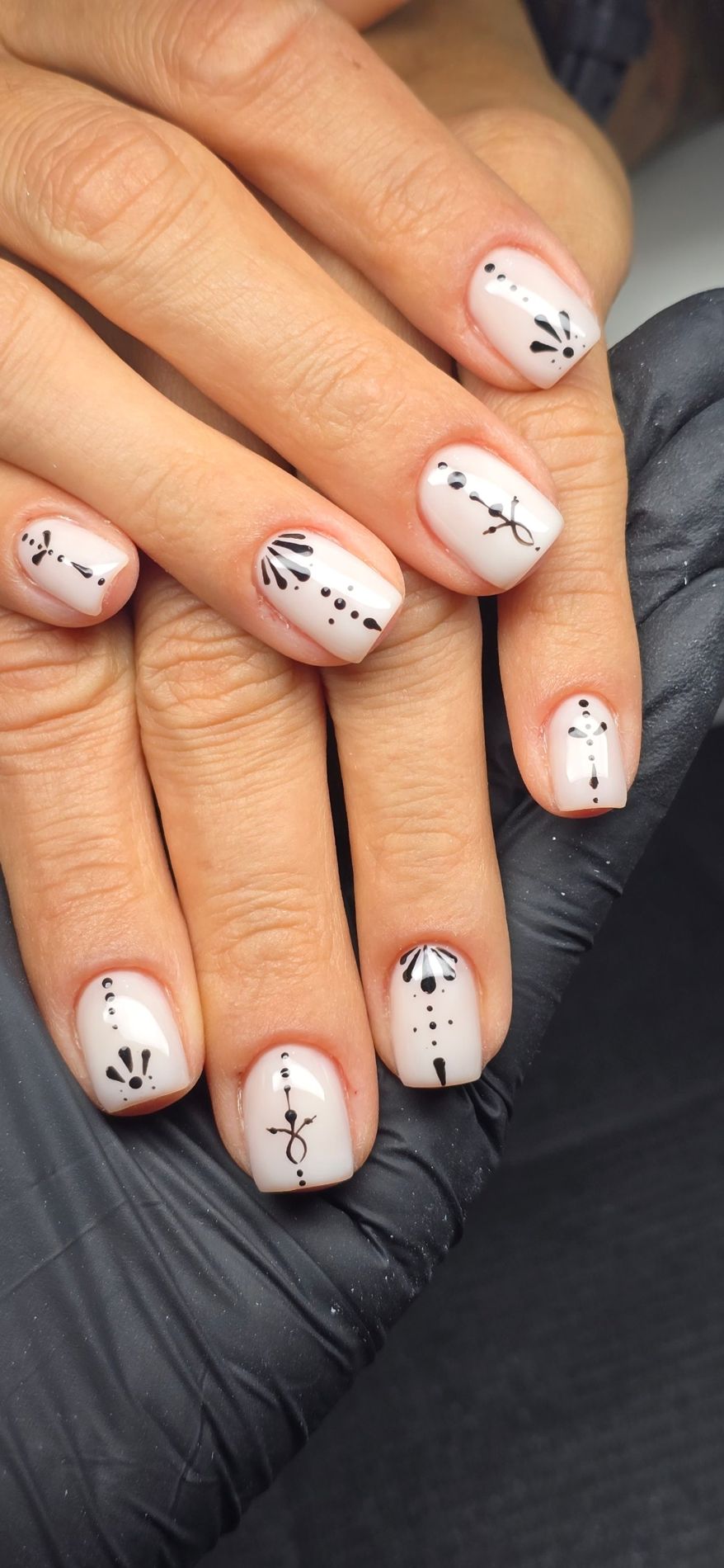 Uñas cortas blanco lechoso con nailart minimalista en negro