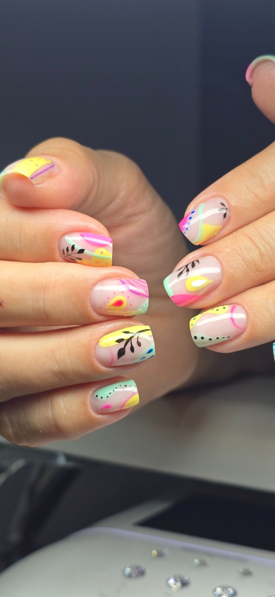 Nailart abstracto en neón, amarillo, rosa y menta con hojas negras