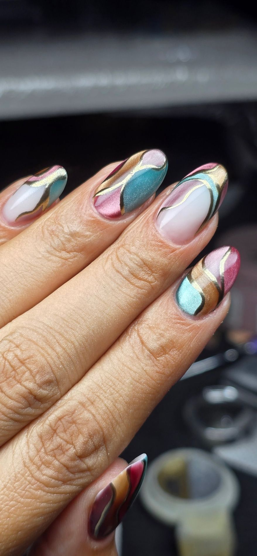 Uñas almendradas con ondas en turquesa, rosa y dorado