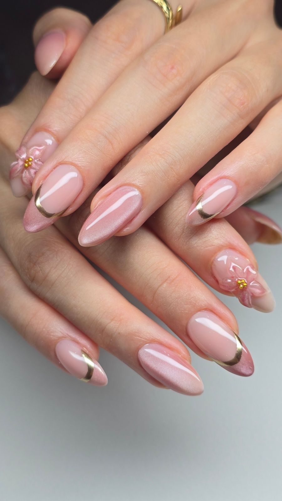 Uñas almendradas rosas con francesa dorada y flor en 3D